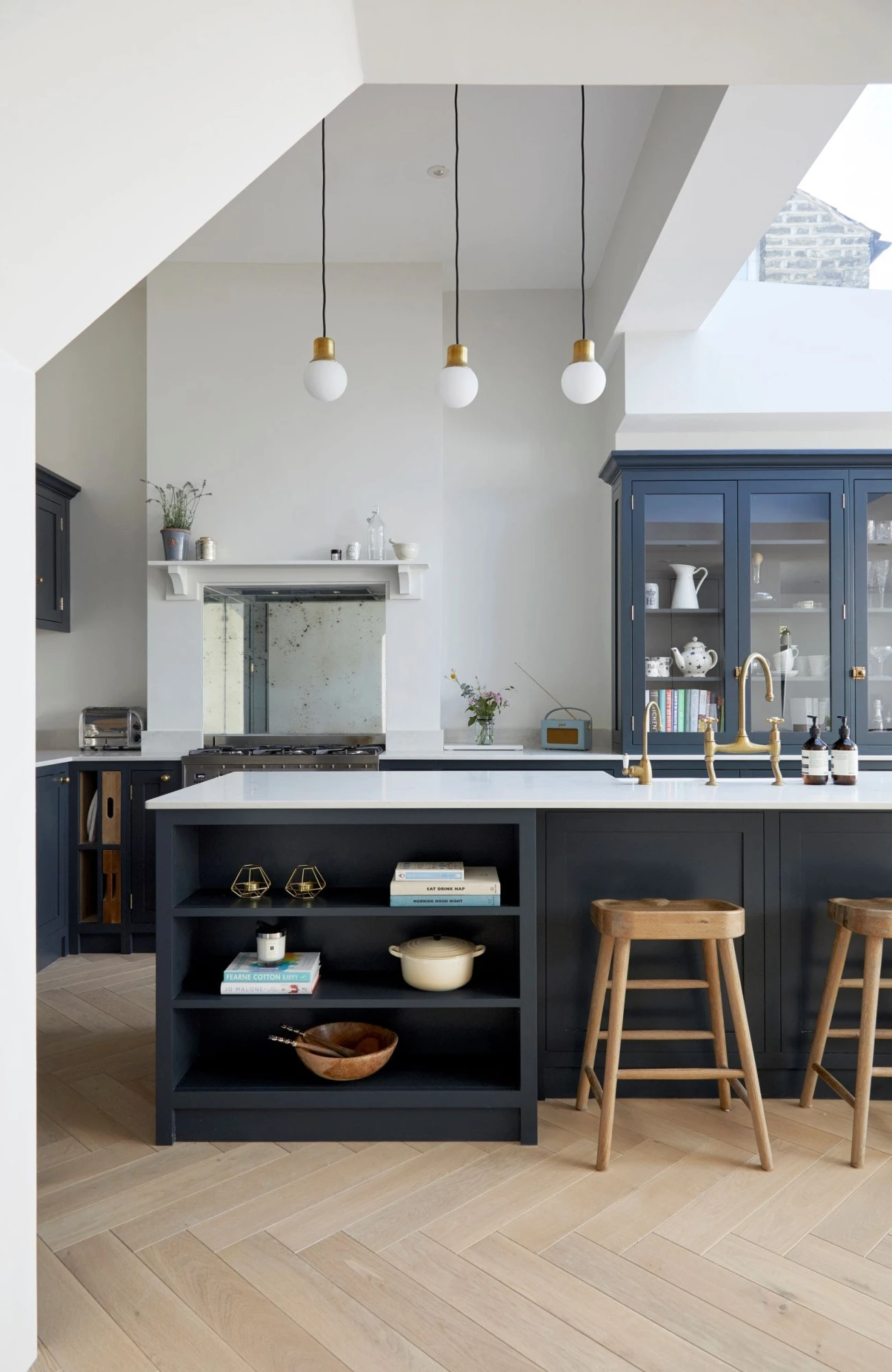 Immerse yourself in the tranquility of the minimalist Heathwood Gardens kitchen, where dark blue cabinetry and white marble worktops blend seamlessly to create a harmonious ambiance. The abundance of natural light, streaming through the windows, further accentuates the kitchen's sleek and elegant design