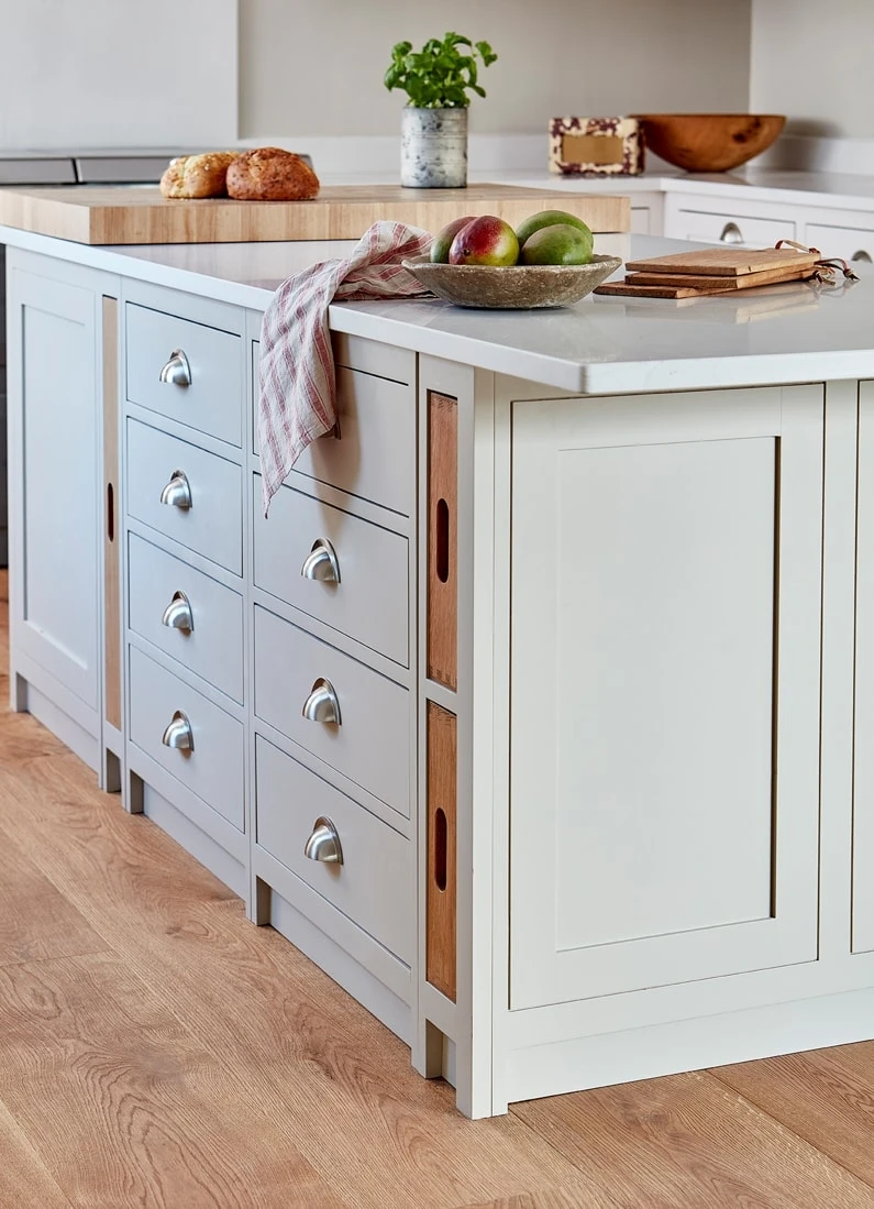 Up-close view of the Hertfordshire Manor kitchen's island, highlighting its elegant oak end grain chopping block. The chopping block, alongside the ample countertop space, provides a practical and durable surface for culinary creations.