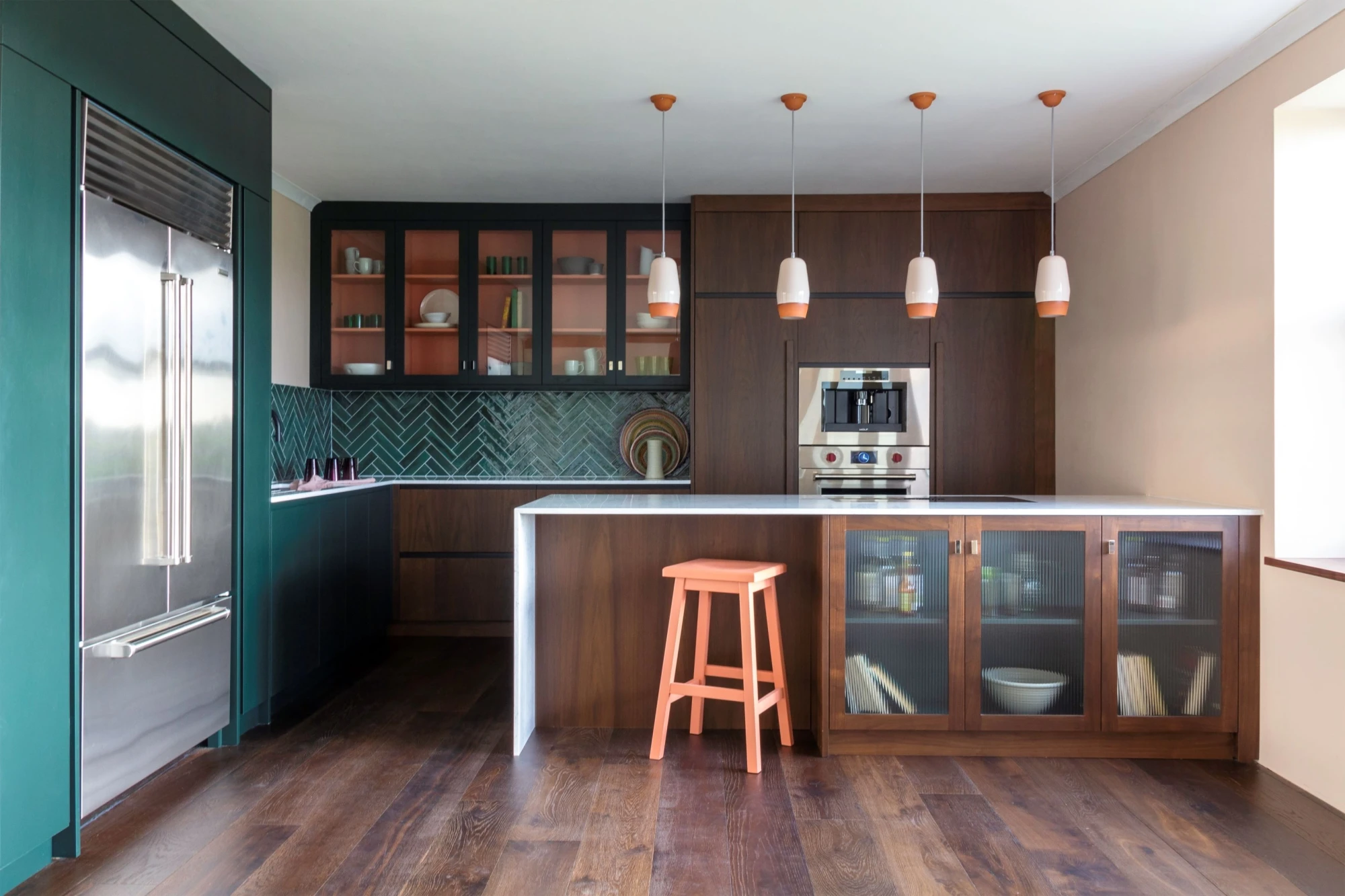 A captivating view of the Blenheim kitchen, featuring rich walnut cabinetry, gleaming brass accents, and vibrant Pamment pops, creating an inviting and sophisticated ambiance.