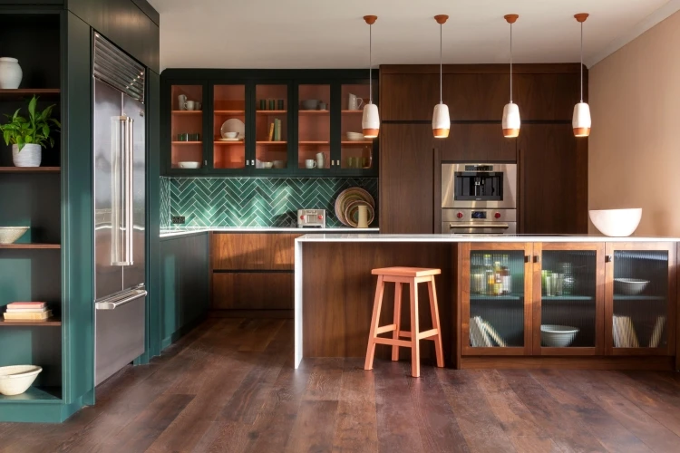 A captivating view of the Blenheim kitchen, featuring rich walnut cabinetry, gleaming brass accents, and vibrant Pamment pops, creating an inviting and sophisticated ambiance.