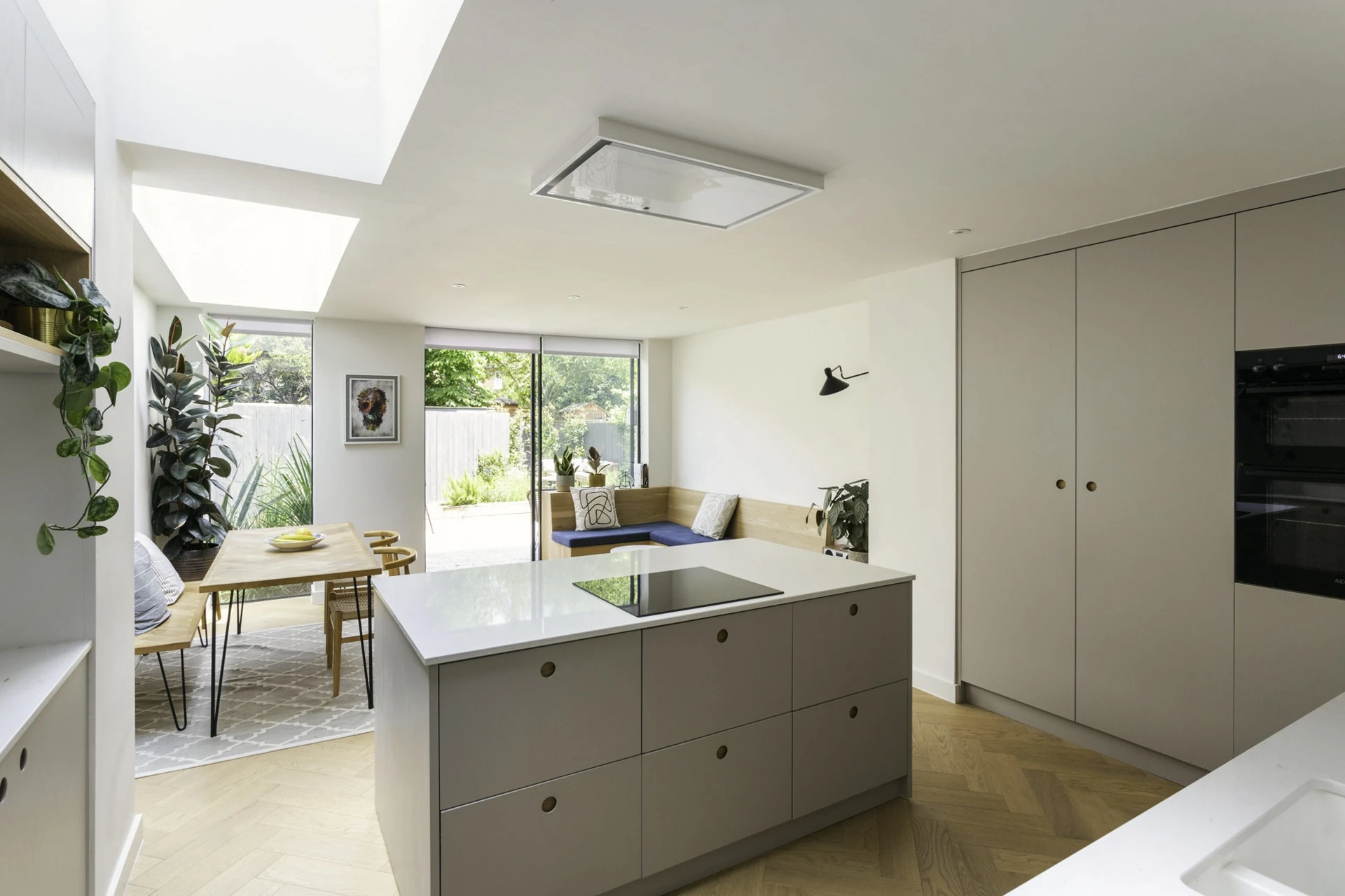 A glimpse into the Camberwell kitchen, showcasing the interplay of dove grey cabinetry, white quartz worktops, and delicate Ladbroke handles, creating a seamless and inviting ambiance.