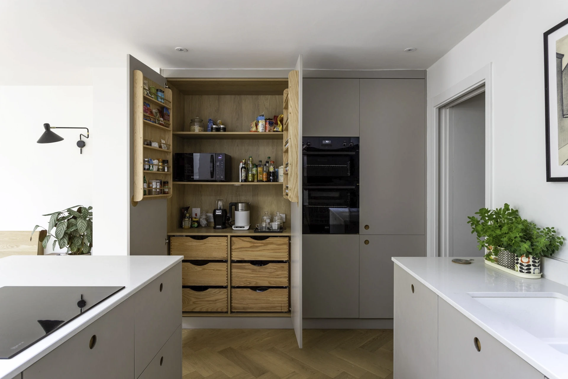 A captivating view of the Camberwell kitchen, featuring soft dove grey cabinetry and delicate Ladbroke handles, exuding a contemporary and elegant aesthetic.