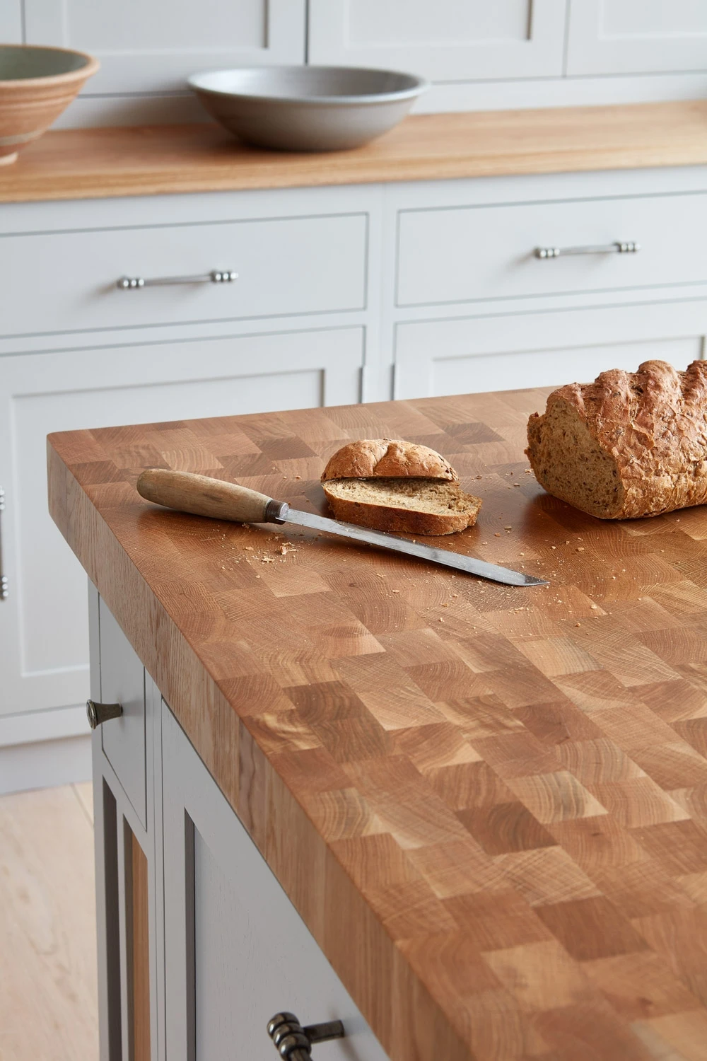 A stylish central island anchors the Cley kitchen, providing additional workspace and seating. The island's quartz countertop seamlessly integrates into the cabinets, creating a cohesive and elegant design.