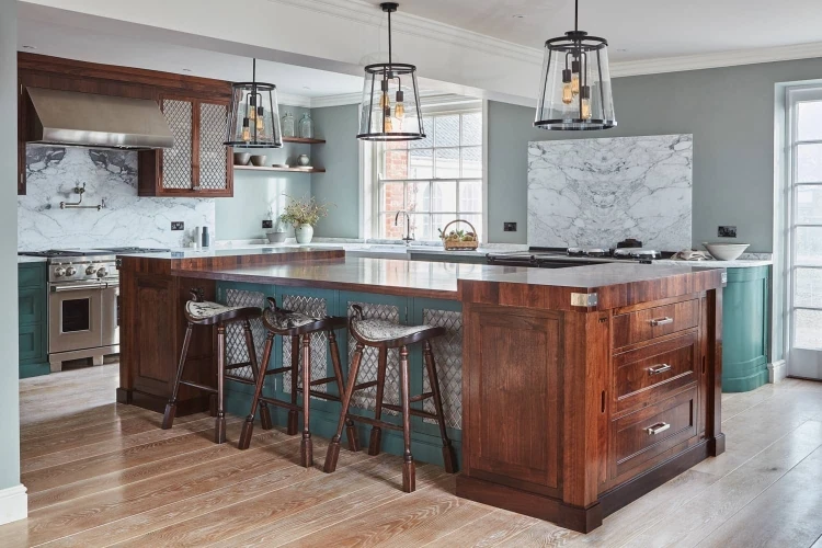 A striking central island forms the heart of the Georgian Hall kitchen, providing additional workspace and seating for gatherings. The island's walnut countertop seamlessly blends with the cabinets, creating a cohesive and elegant design.