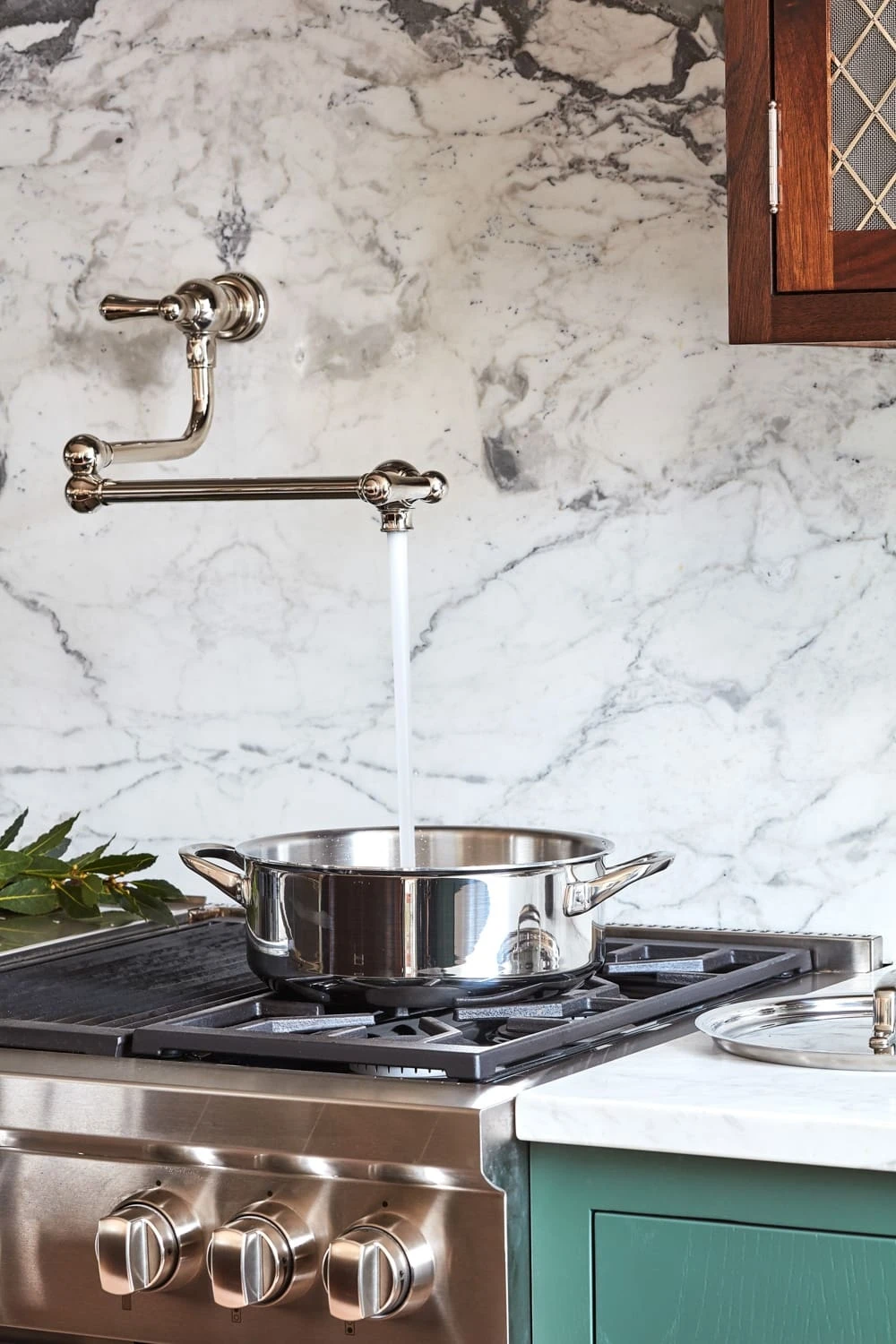 Strikingly positioned over the stovetop, the kitchen's pot filler adds convenience and style to the cooking experience. The pot filler's brass finish complements the kitchen's overall elegance.