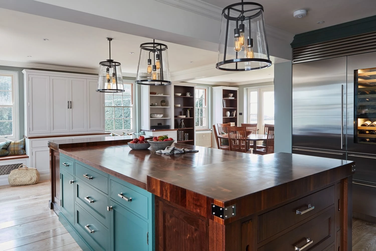 A striking central island forms the heart of the Georgian Hall kitchen, providing additional workspace and seating for gatherings. The island's walnut countertop seamlessly blends with the cabinets, creating a cohesive and elegant design.