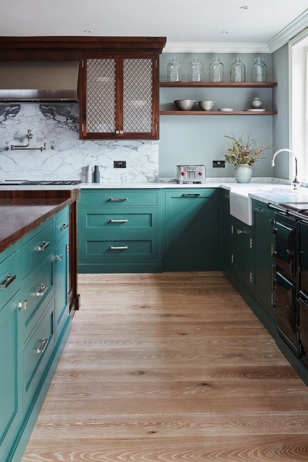 The Georgian Hall kitchen exudes timeless elegance, blending green Shaker cabinetry with white marble countertops, walnut worktops, mesh centrepieces, and a central island. The kitchen's simplicity and functionality make it a perfect centrepiece 
                                    for any home.