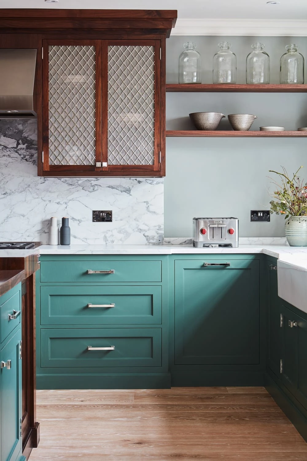 The Georgian Hall kitchen exudes timeless elegance, blending green Shaker cabinetry with white marble countertops, walnut worktops, mesh centrepieces, and a central island. The kitchen's simplicity and functionality make it a perfect centrepiece 
                                    for any home.