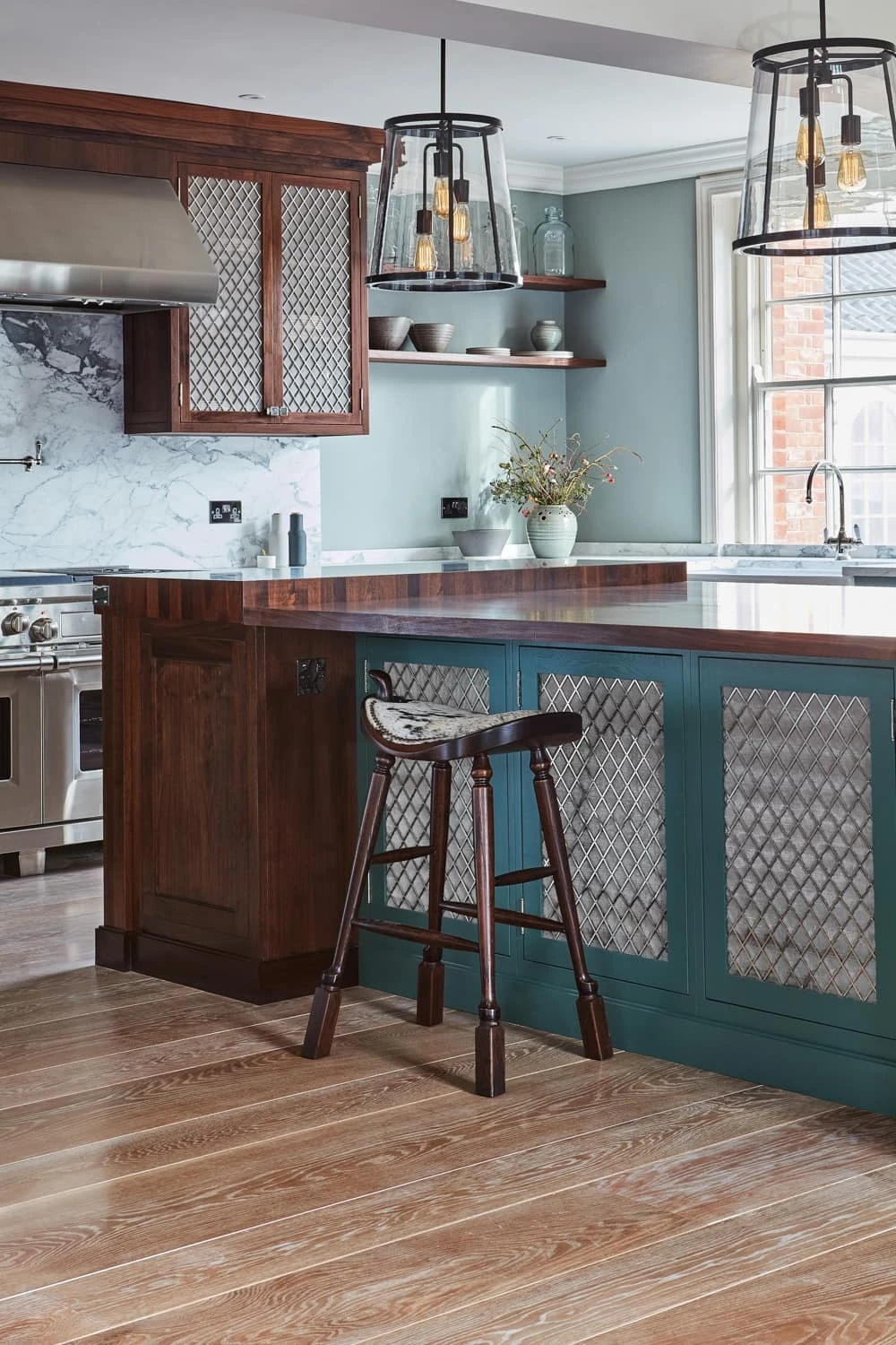 Stepping into the Georgian Hall kitchen, you are greeted with an opulent and inviting ambiance, where walnut worktops, mesh centrepieces, and white marble worktops intertwine to create a timeless aesthetic. The large windows allow an abundance of natural light to flood the space, further enhancing its elegance