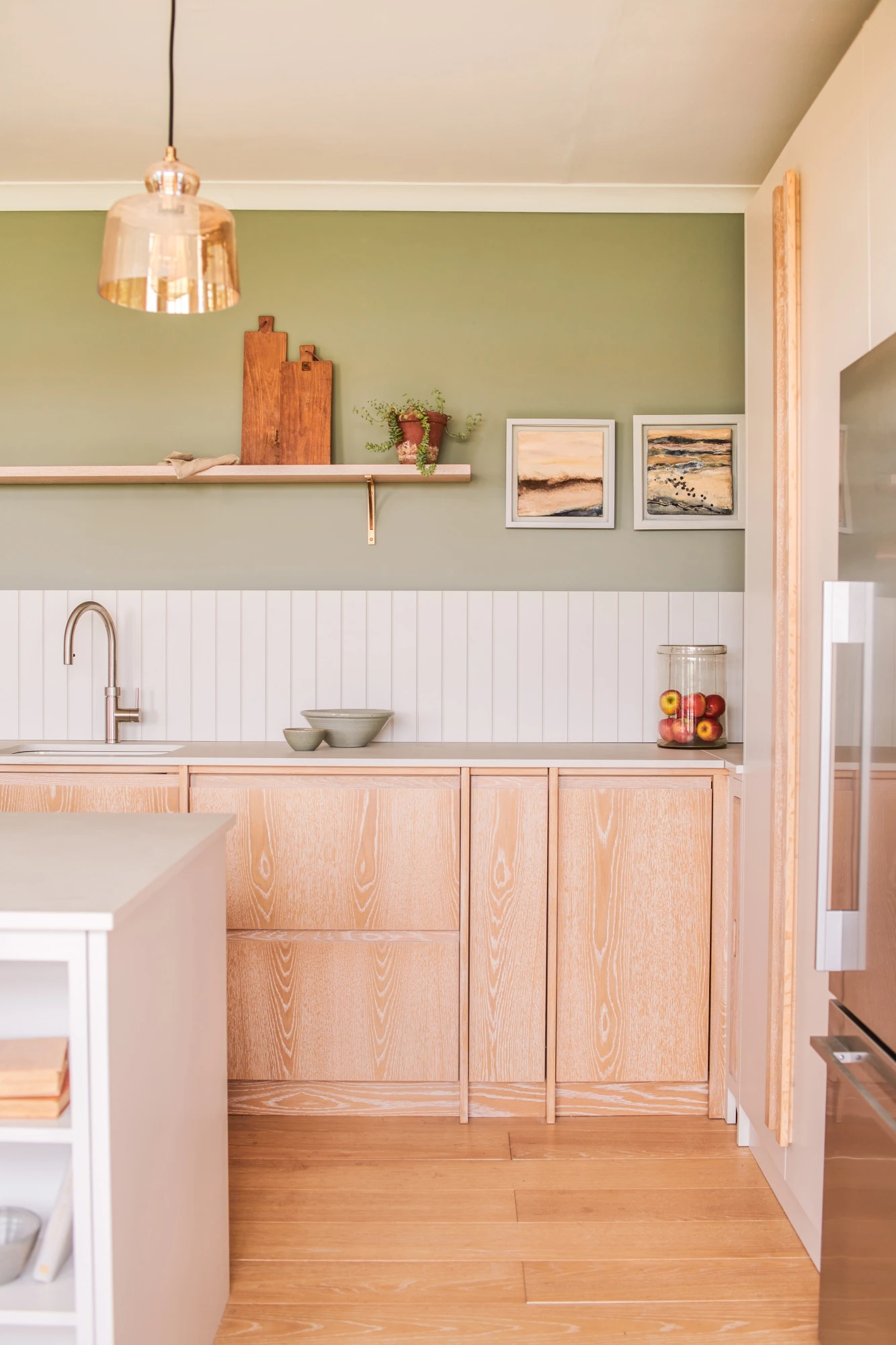 Durability meets sophistication in this Glaven kitchen, with sleek Caesarstone concrete worktops providing a durable and elegant surface for culinary creations, while end panels between each cabinet add a decorative element, enhancing the kitchen's overall aesthetic.