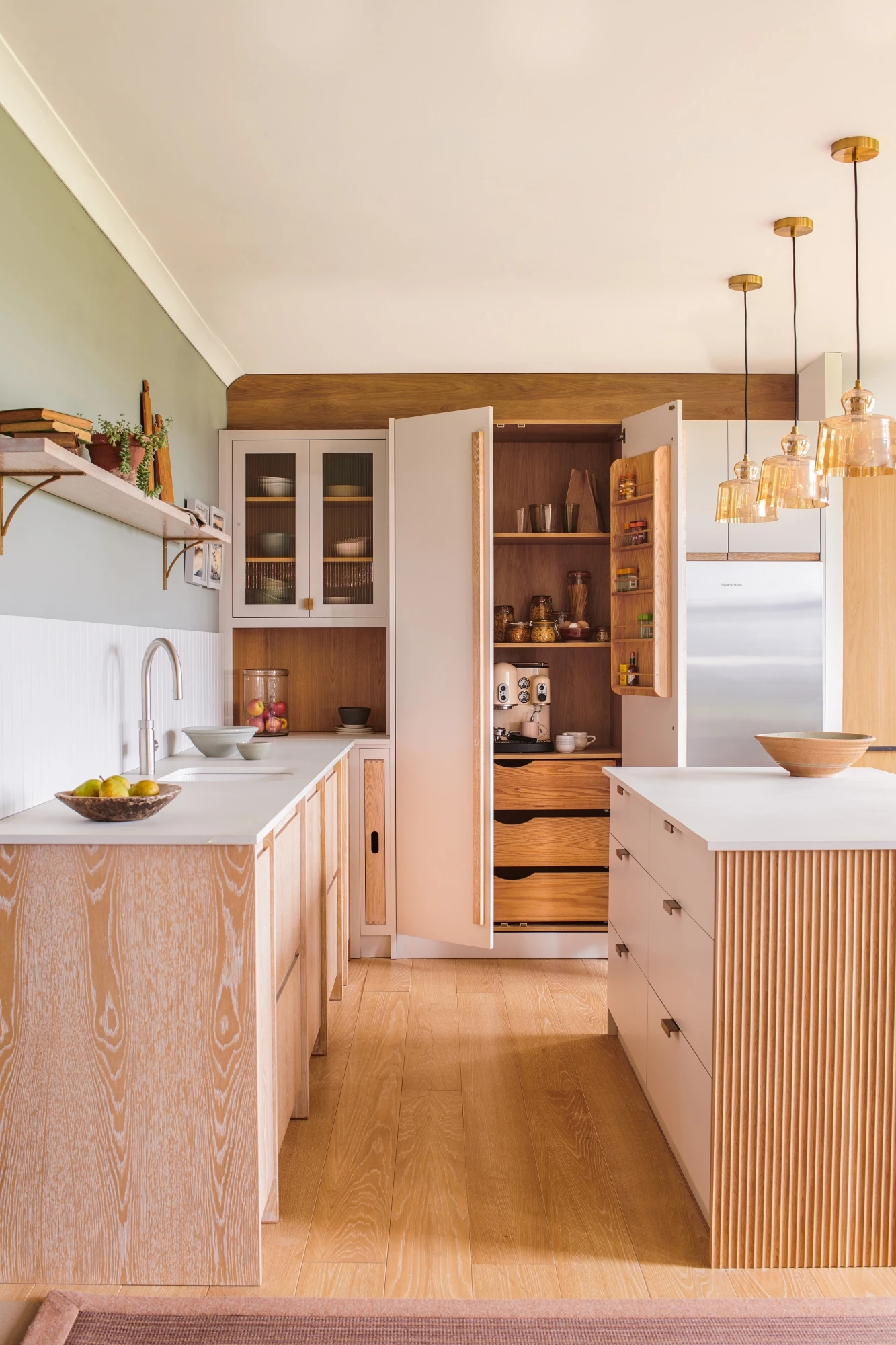 Texture and dimension are effortlessly achieved in this Glaven kitchen, with glazed units adding depth and character, and a panelled splashback providing a touch of visual interest, enhancing the kitchen's contemporary appeal.