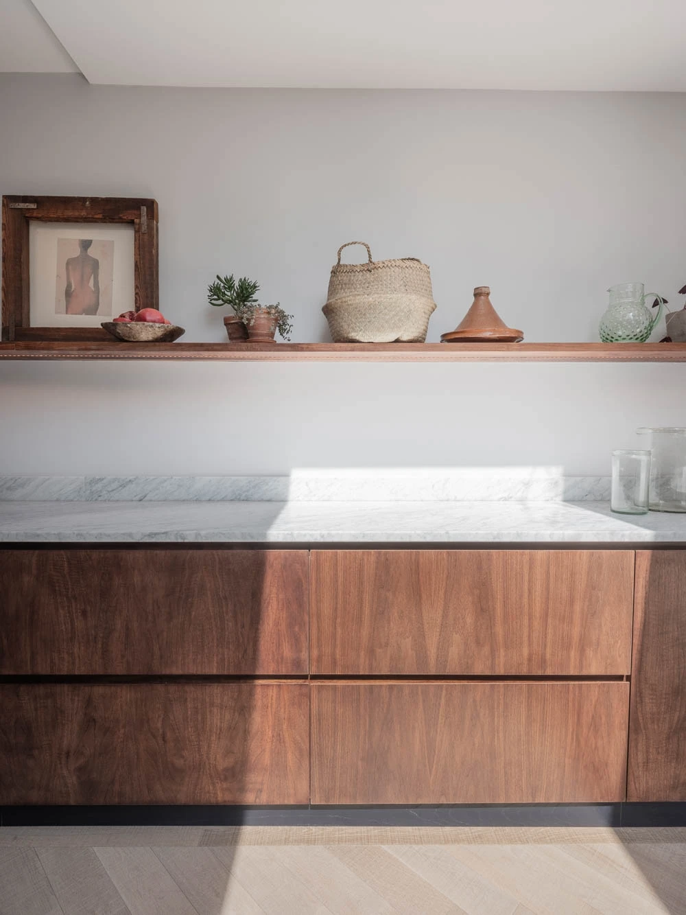 The Highgate kitchen's sophisticated color scheme of black walnut, white marble, and pale walls creates a harmonious and elegant ambiance. The contrast between the dark walnut and the light marble adds depth and visual interest, while the pale walls provide a calming backdrop for the kitchen's rich tones.