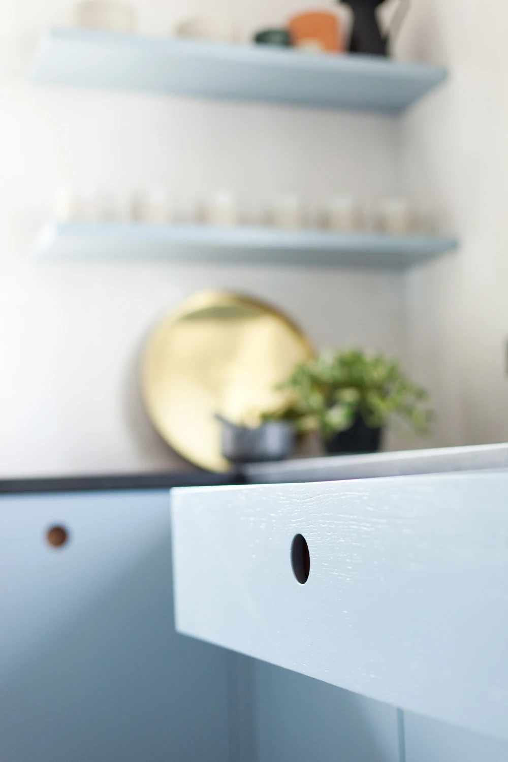 A bespoke Ladbroke kitchen featuring cherry wood handles for a unique, characterful touch. Subtle blue and white hues create a relaxed atmosphere with textured finishes.