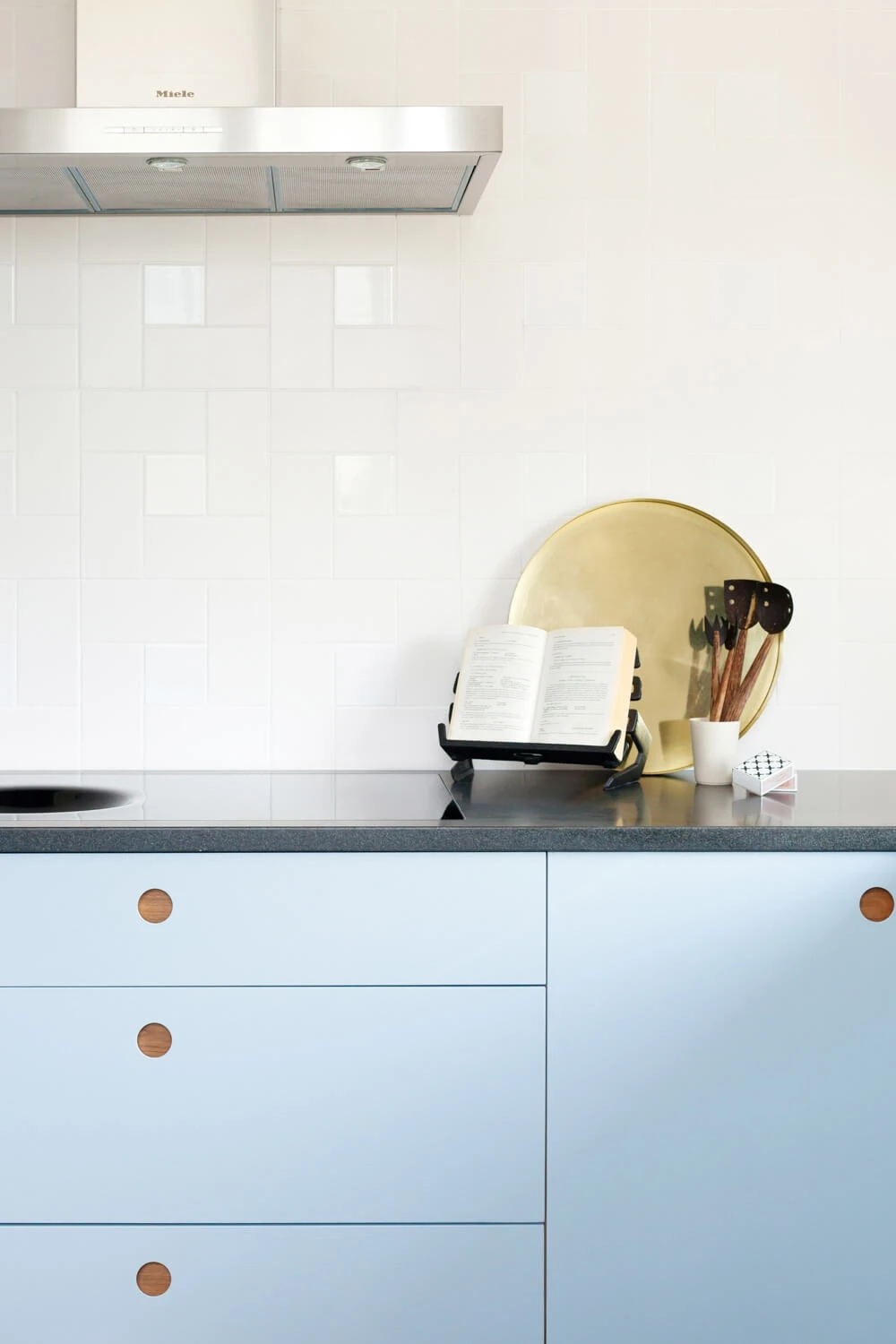 A bespoke Ladbroke kitchen featuring cherry wood handles for a unique, characterful touch. Subtle blue and white hues create a relaxed atmosphere with textured finishes.