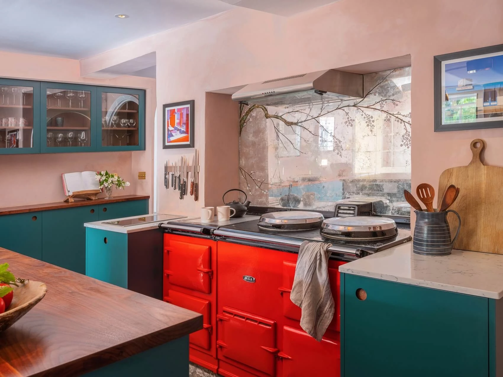 Circular handle details and a bold red Aga set the stage for a sophisticated kitchen masterpiece.