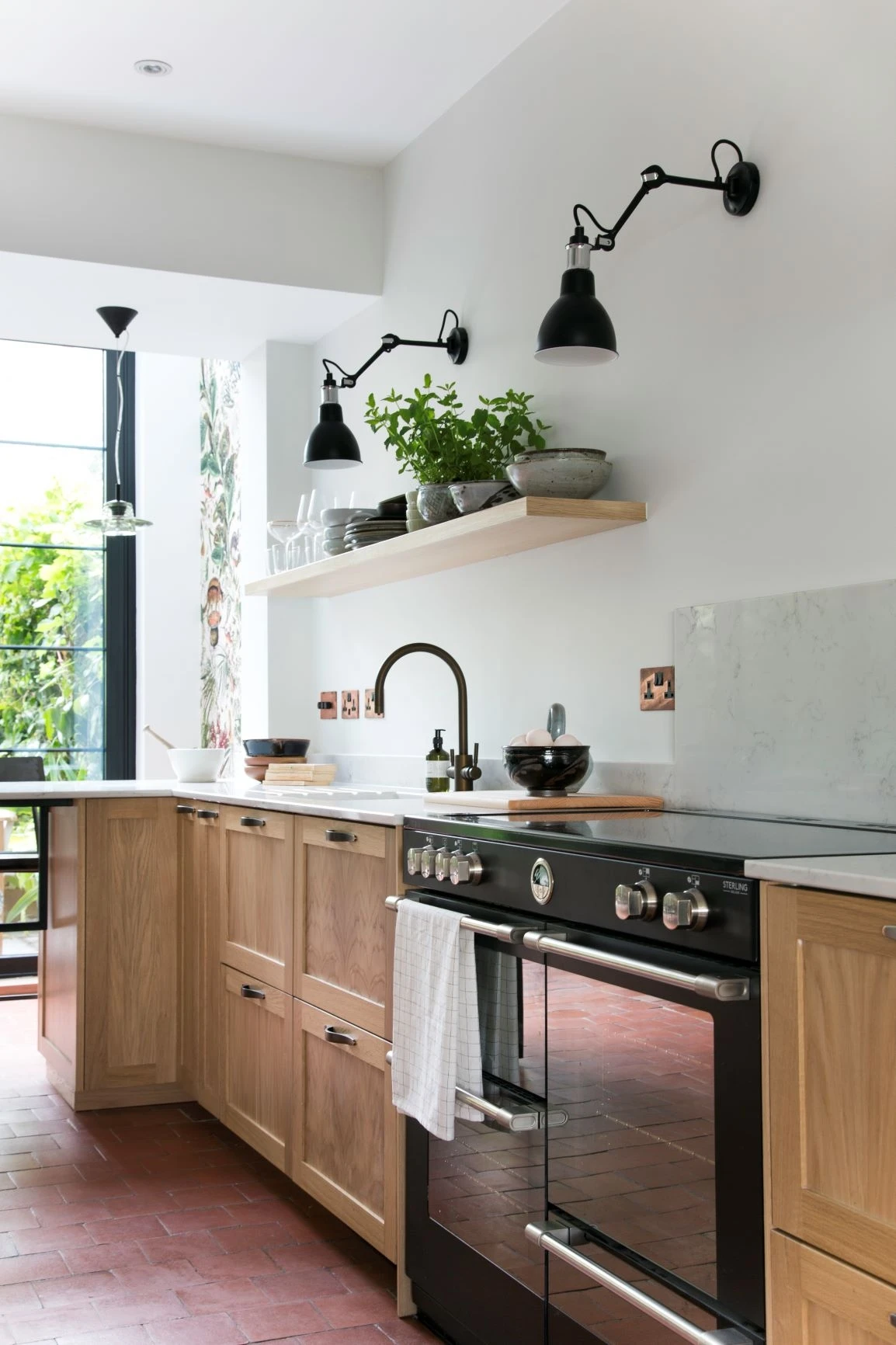 Playful wallpaper adds a touch of whimsical personality to the kitchen and complements the smooth green paint.