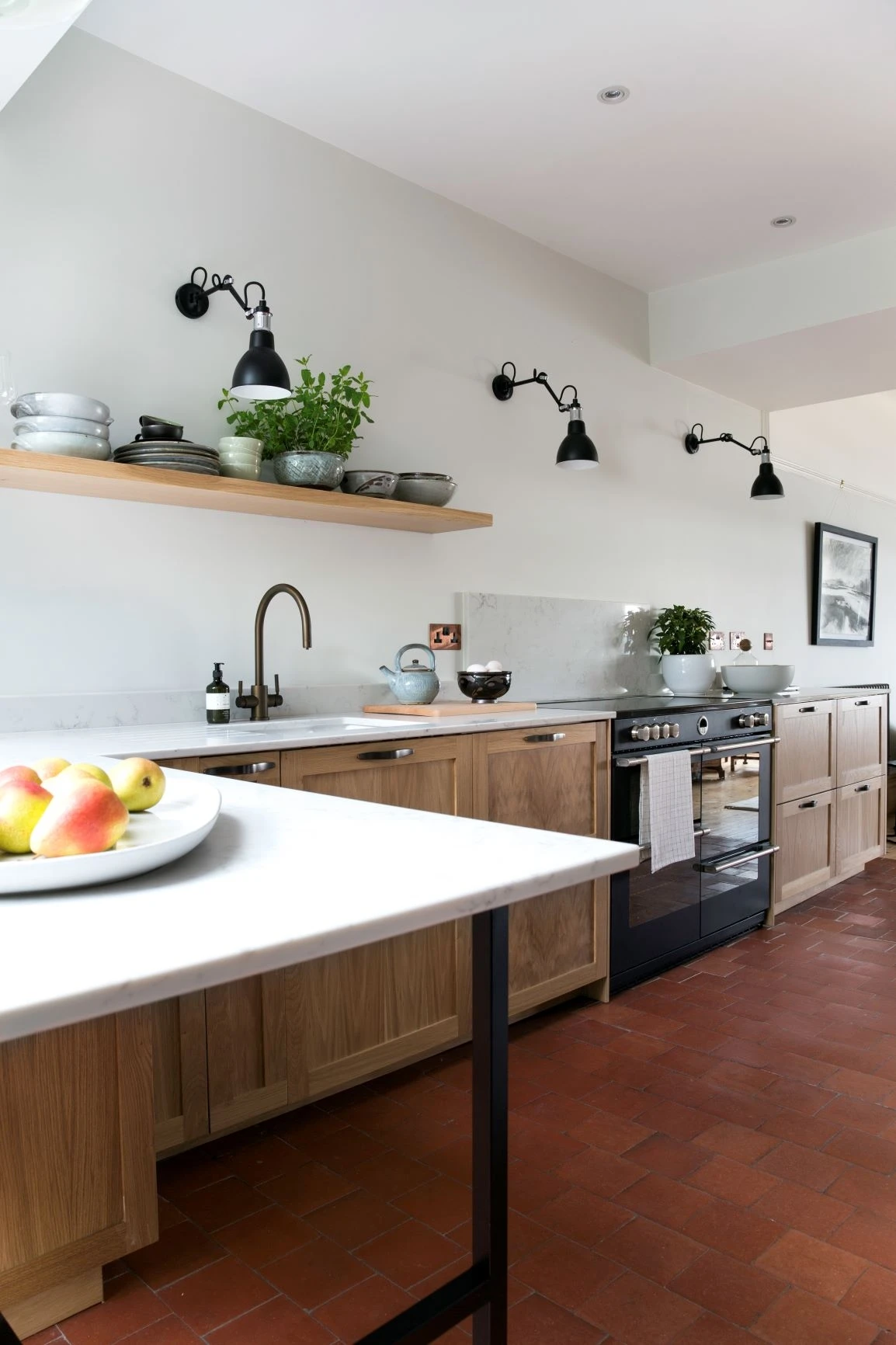 A splash of vibrant red tiles adds a playful touch and draws the eye in this mix-material kitchen.