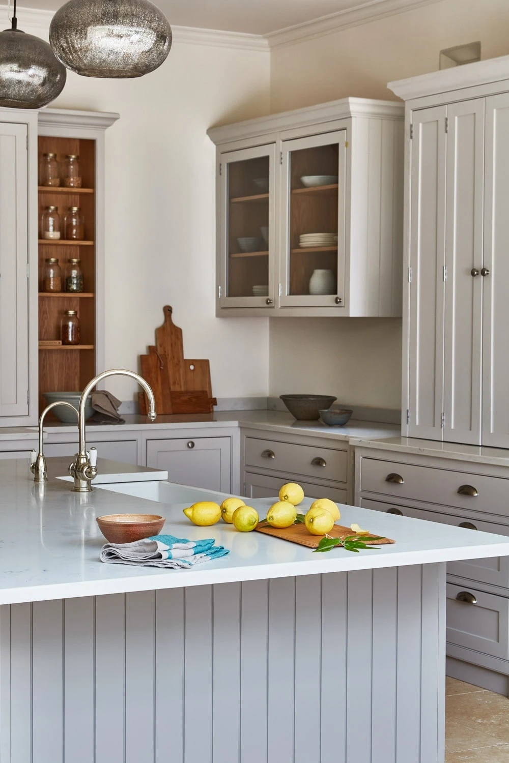 Charming angle of the Norfolk Vicarage kitchen, showcasing the open shelving and glass-fronted cabinets that showcase curated pieces and add a touch of personality. The open shelving adds a sense of lightness and airiness to the space.