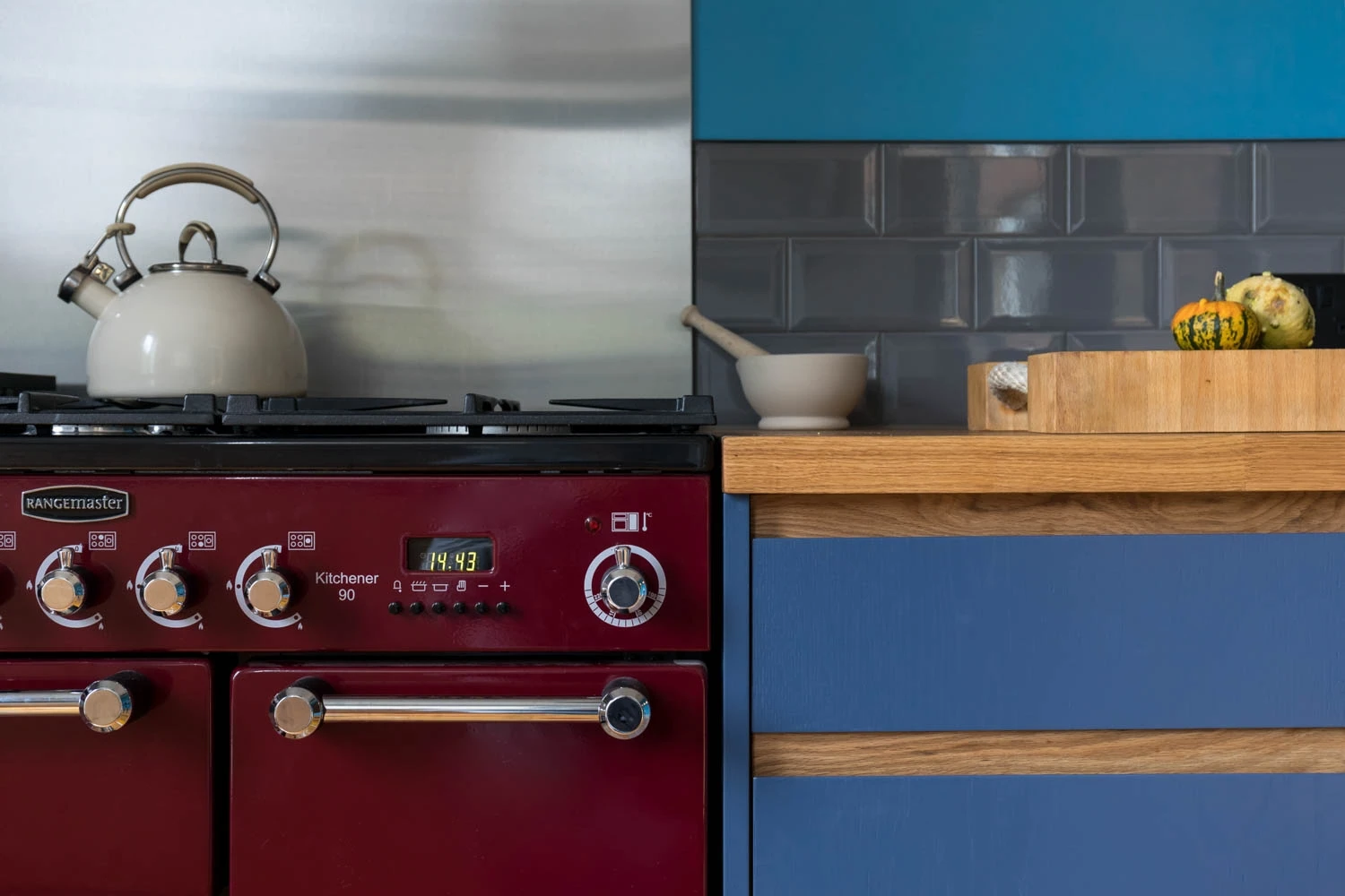 Showstopping red Rangemaster delivers culinary firepower, perfectly complemented by the clean lines of blue J-groove cabinets, creating a kitchen inspired by both form and function.