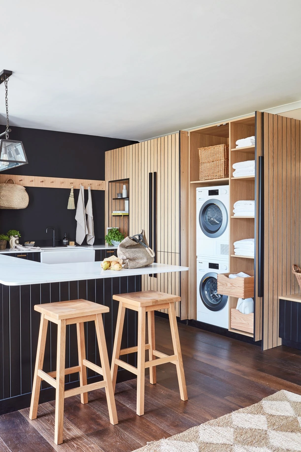 Ample storage solutions in the Kitchen, including stacked washing machine and dryer units neatly hidden behind pocket doors, maximising space utilisation.