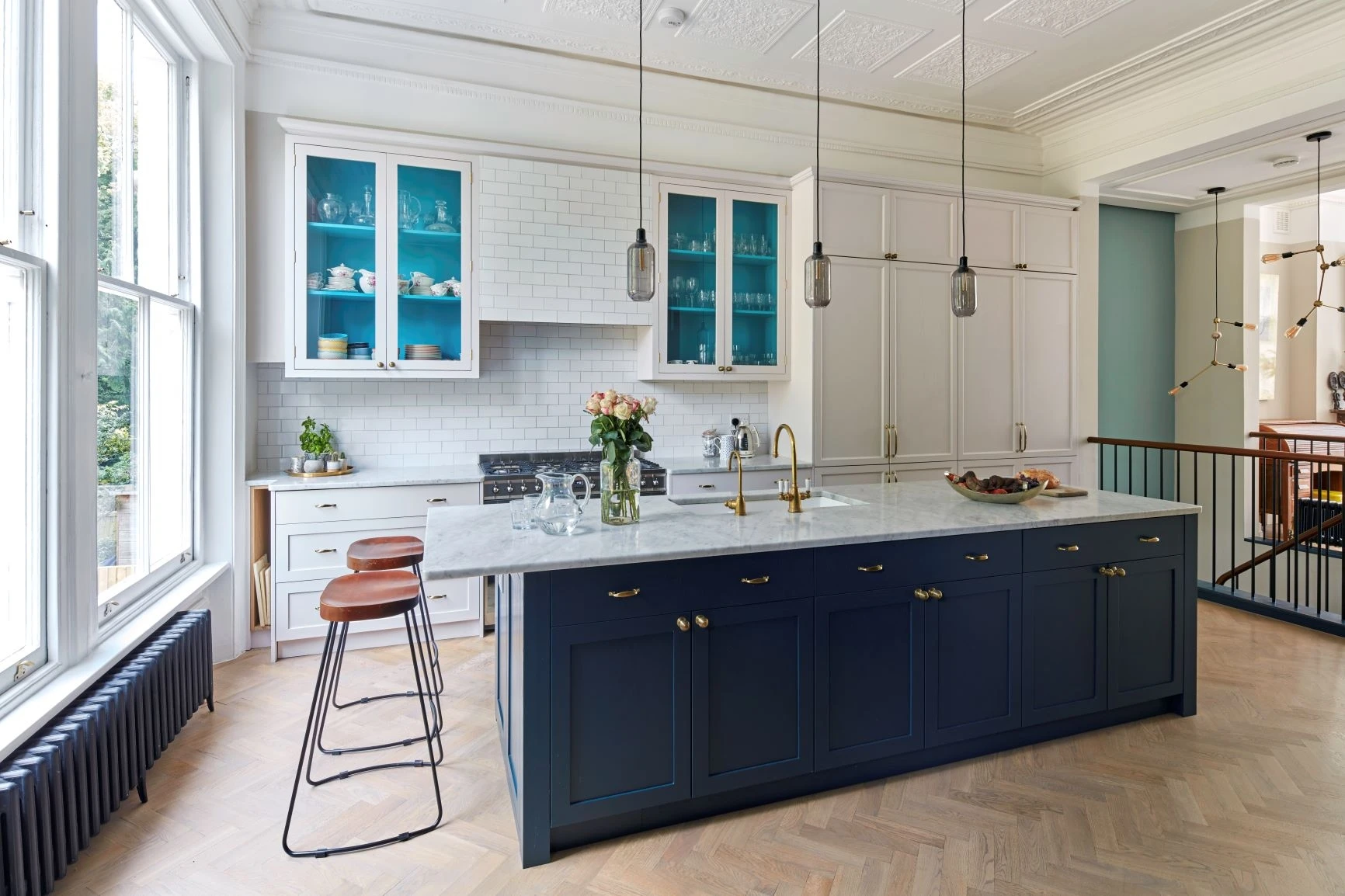 A stylish central island anchors the Chepstow Villas kitchen, providing additional workspace and seating. The island's quartz countertop seamlessly integrates into the cabinets, creating a cohesive and elegant design.