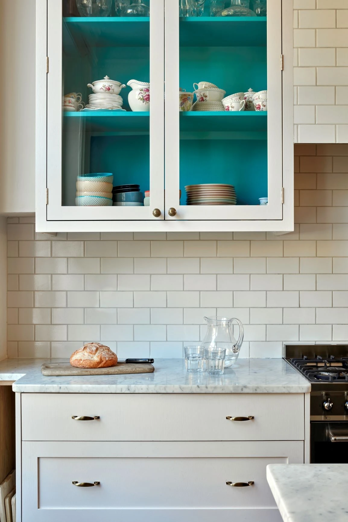 A shaker style kitchen unit with brass handles and white quartz worktop and a glazed shaker wall unit is a classic and timeless combination that never goes out of style. The shaker style cabinets are known for their clean lines and simple, elegant design, while the brass handles add a touch of luxury and sophistication.