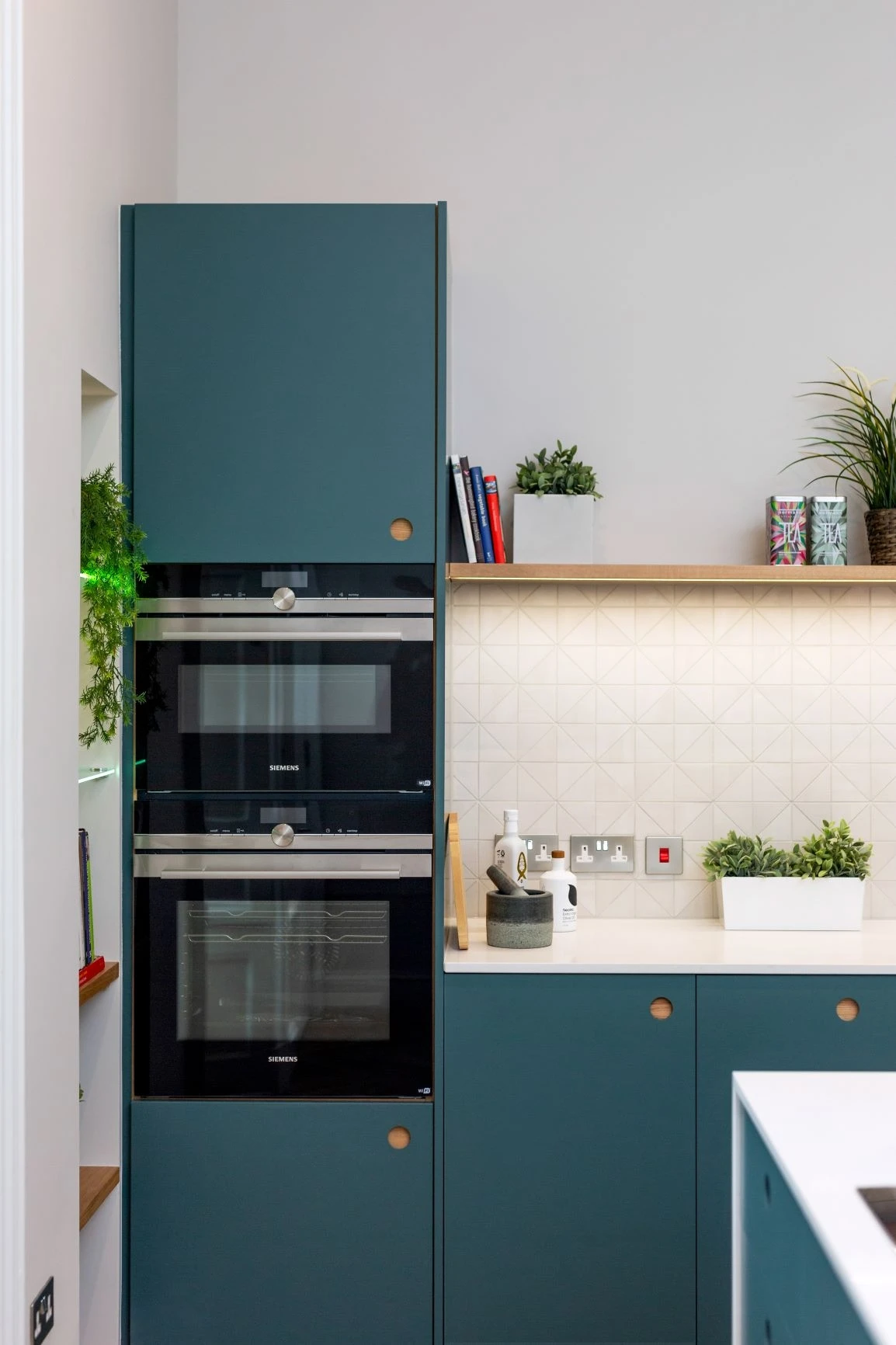 The Royal Mile kitchen seamlessly integrates appliances, such as Miele ovens, a dishwasher, and a hob, all tucked away. This clever design maximizes space and creates a clean and clutter-free look, while also maximizing the kitchen's space.